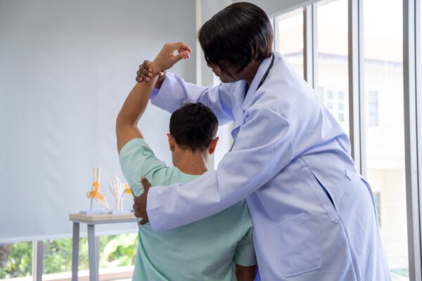 Doctor evaluating a patient for musculoskeletal medicine treatment involving muscles, bones, and joints